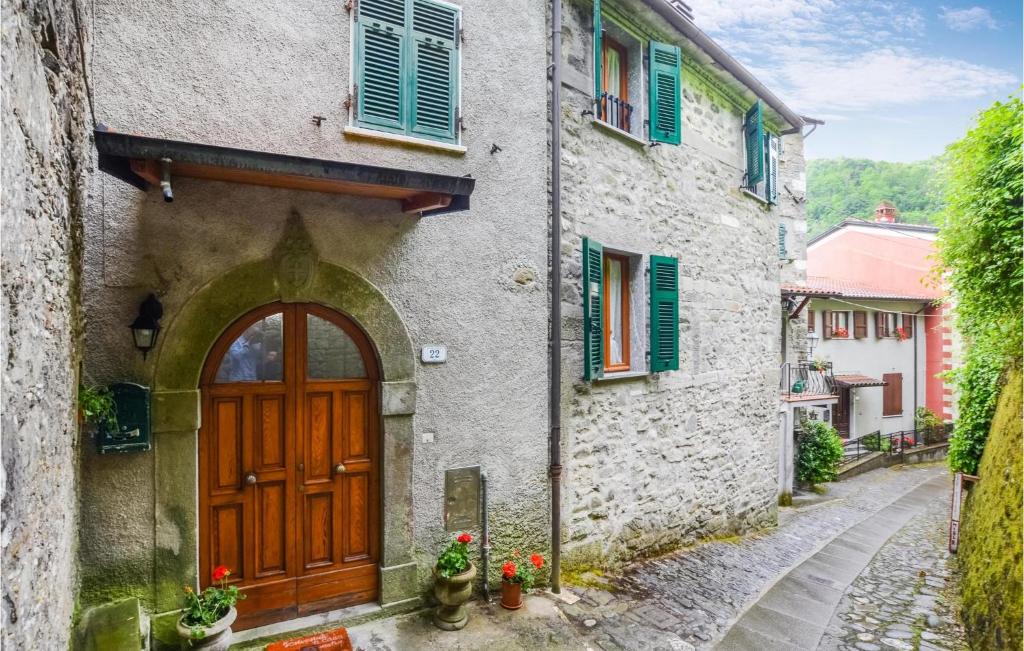 un edificio antiguo con una puerta de madera y una calle en 1 Bedroom Nice Home In Equi Terme, en Equi Terme