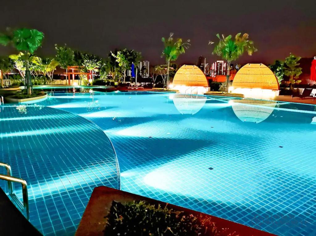 una gran piscina por la noche con luces en Almas Suites Puteri Harbour by Stayrene en Nusajaya