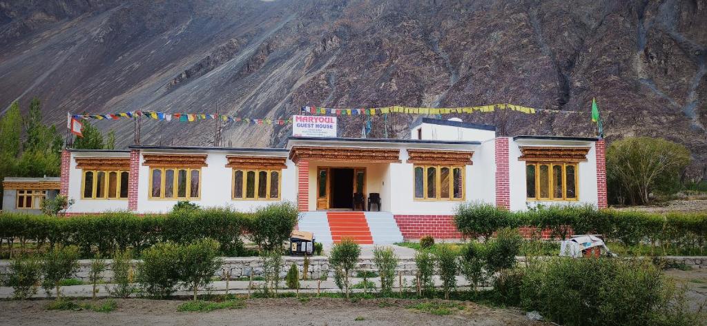 a house with a mountain in the background at Maryoul Guest House, Hunder Nubra in Hundar