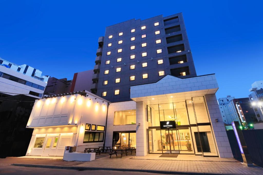 札幌的住宿－QuintessaHotel SapporoSusukino63 Relax&Spa，前面有桌子的大建筑