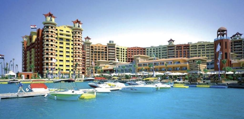 a group of boats in a marina with buildings at private chalets in porto marina in El Alamein