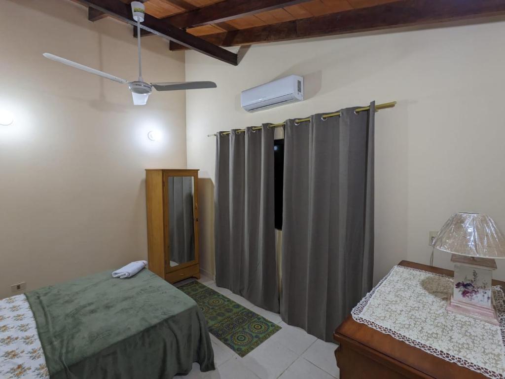 1 dormitorio con cama y cortina de ducha en Cómoda casa independiente, en Capiatá