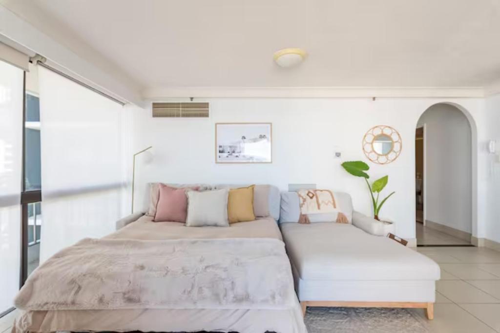 um quarto com uma cama grande e um sofá em Longbeach Luxe, Surfers Paradise em Gold Coast