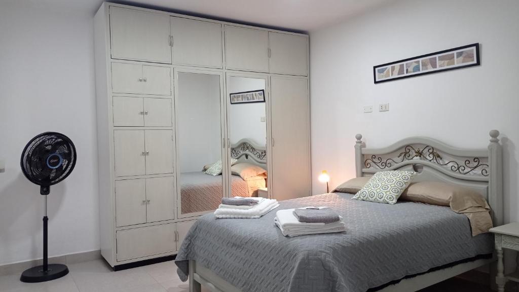 a bedroom with a large white bed and a mirror at Apartamento Privado SOL in Tarija