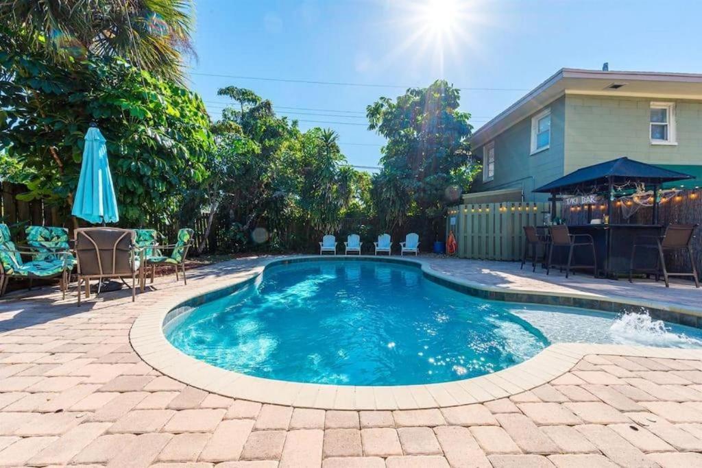 a swimming pool in a yard with chairs and an umbrella at Resort-style Estate w/ Pvt Guest Suites- Sleeps 15 in West Palm Beach