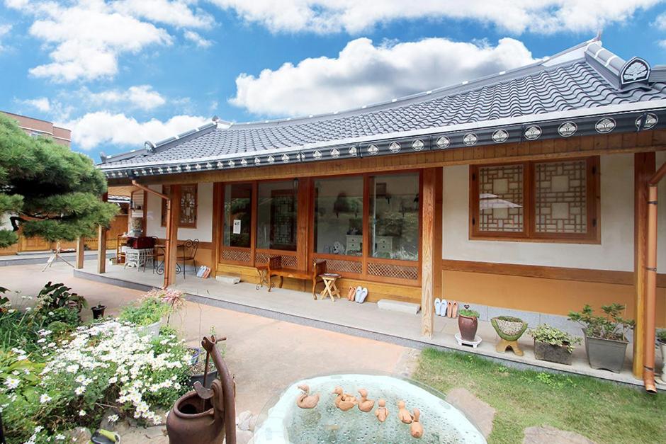 una casa con una fuente frente a ella en Moran Guesthouse en Jeonju
