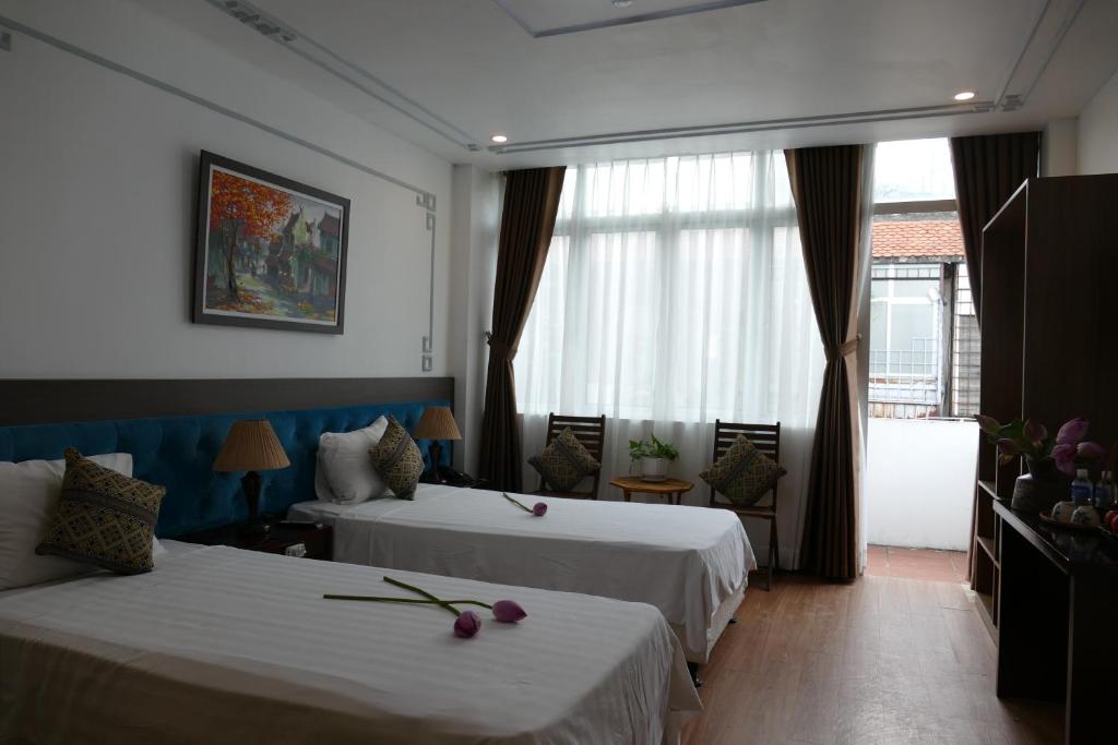 Postel nebo postele na pokoji v ubytování Maison d'Hanoi Hotel