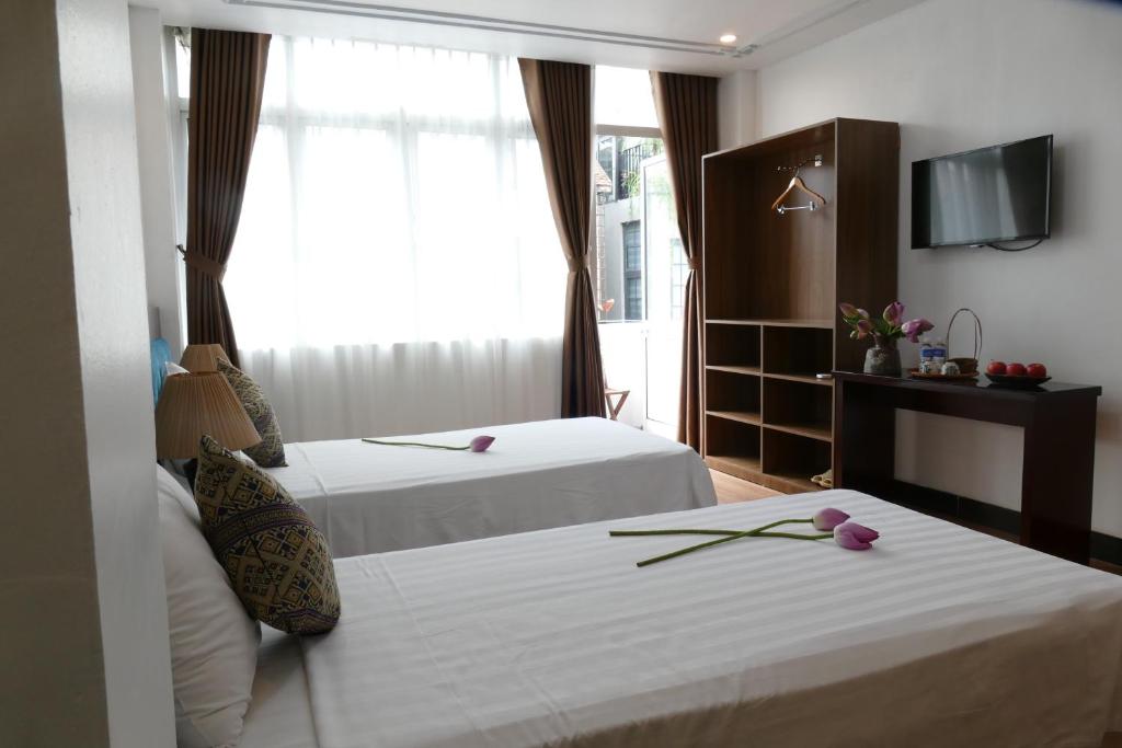 Postel nebo postele na pokoji v ubytování Maison d'Hanoi Hotel