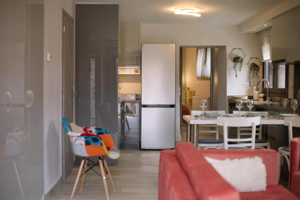 eine Küche und ein Wohnzimmer mit einem Kühlschrank in der Unterkunft Το Σπίτι της Ευτυχίας Σουίτα in Karpenisi