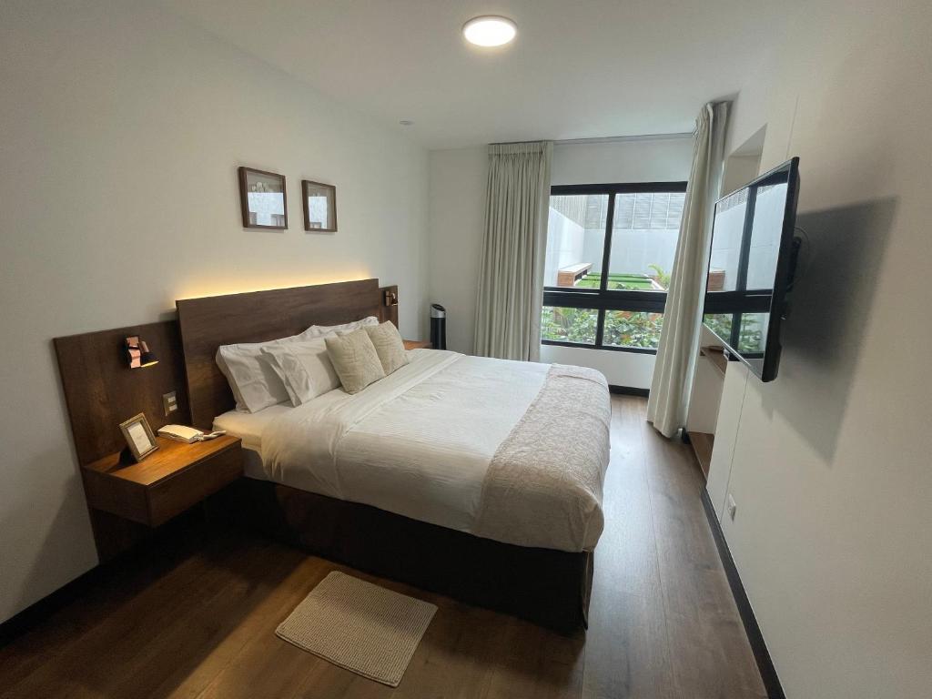 1 dormitorio con cama grande y ventana grande en Executive Apartments San Isidro Business Zone en Lima