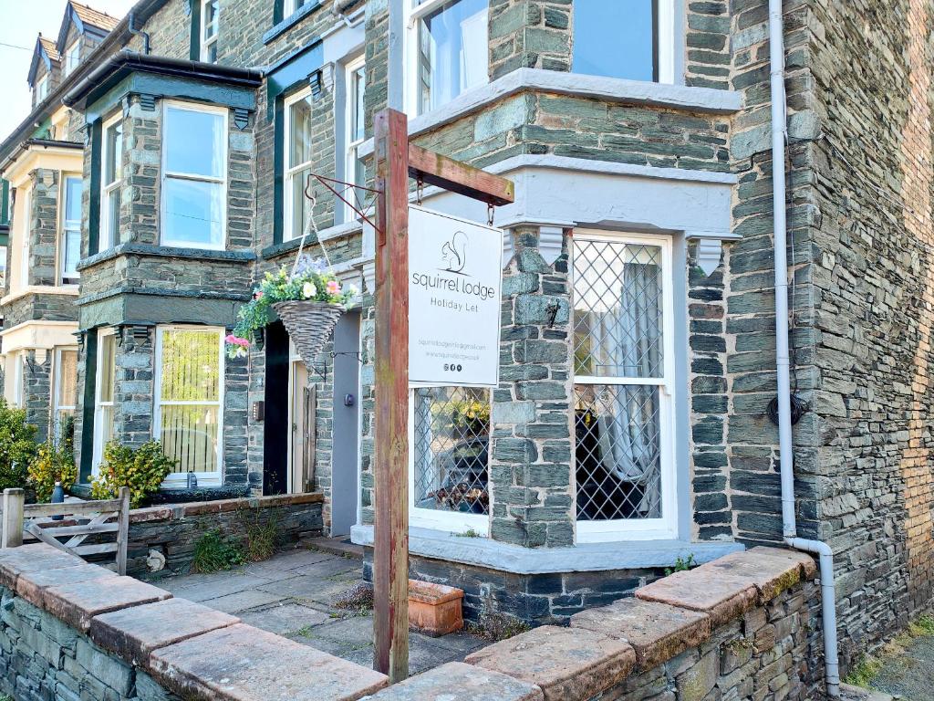 a brick house with a sign in front of it at Squirrel Lodge in Keswick