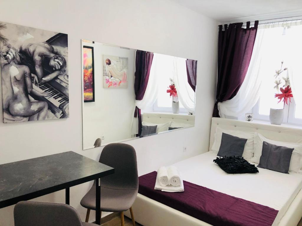 Schlafzimmer mit einem Bett, einem Tisch und Stühlen in der Unterkunft Central Petit Room in Braşov