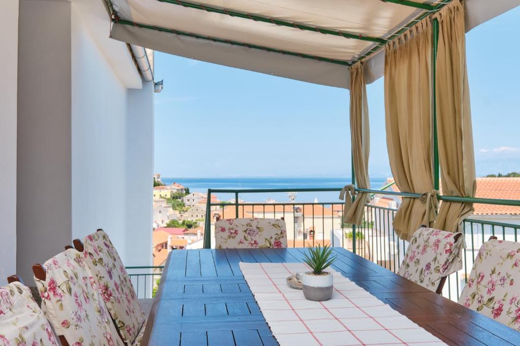 stół i krzesła na balkonie z widokiem na ocean w obiekcie Sea View Apartment Sandra in Mali Lošinj w miejscowości Mali Lošinj