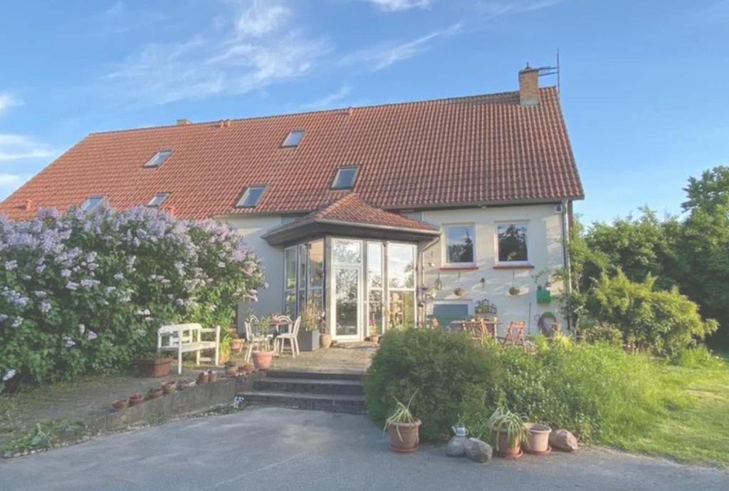 a white house with a red roof at KULTURGUTLEBEN Boutiquehotel Seminarhaus in Möllenbeck