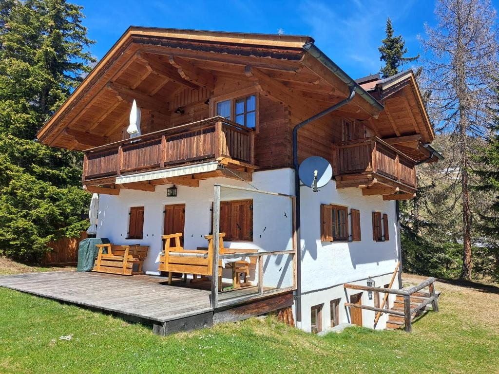 ein Haus mit einer Veranda und einer Terrasse in der Unterkunft Chalet Faschingalm in Debant