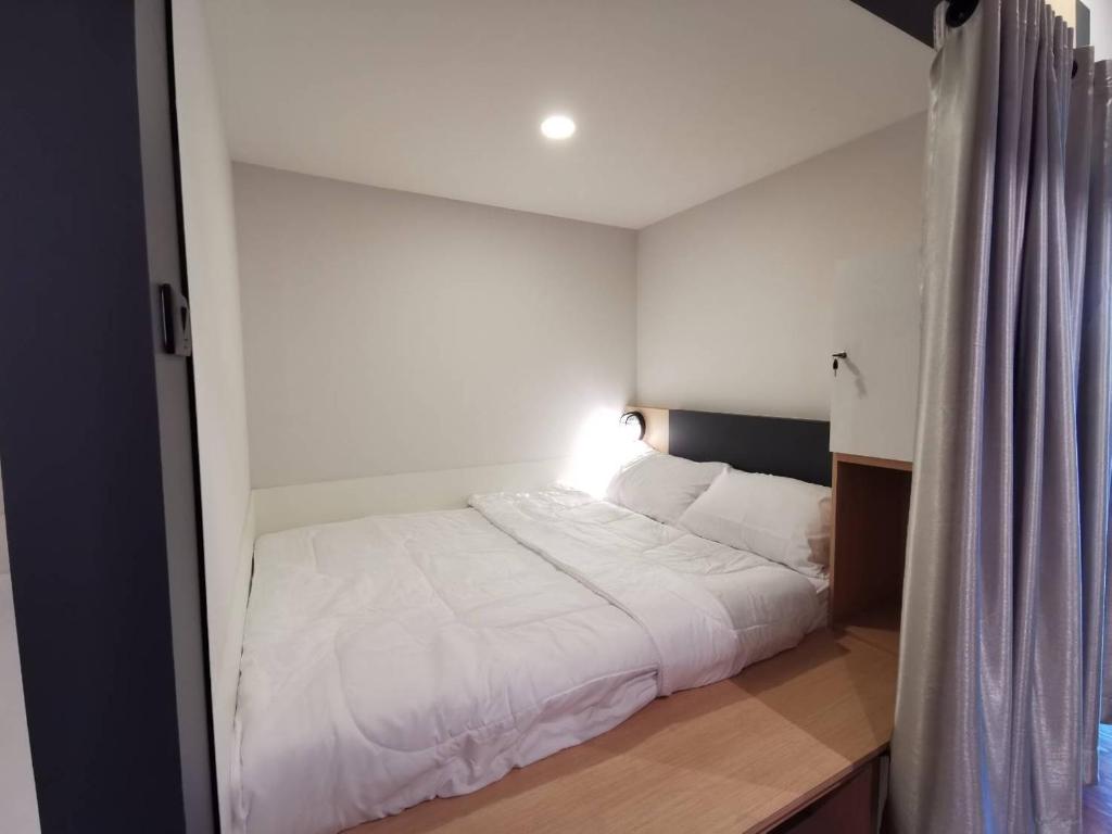 1 dormitorio con 1 cama blanca grande en una habitación en W2 Hostel en Chiang Mai