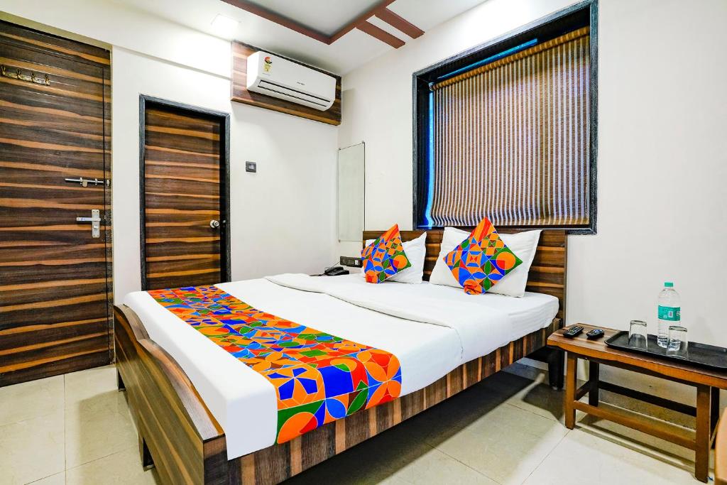 a bedroom with a large bed and a desk at FabExpress Shalimar in Mumbai