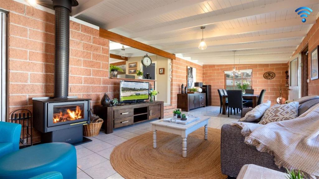 a living room with a couch and a fireplace at Cudgee in Currarong