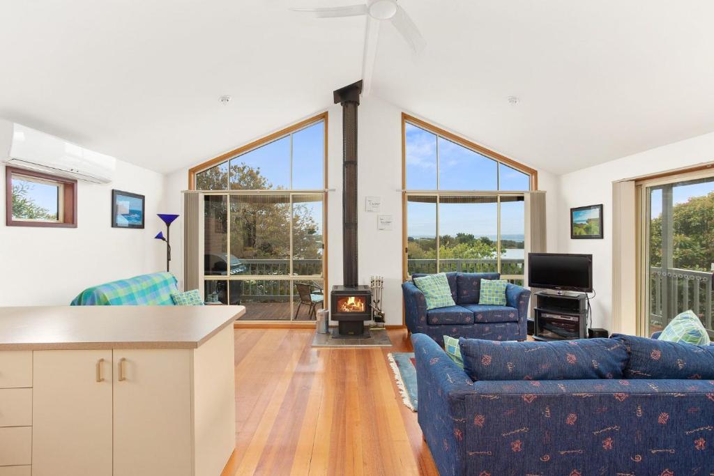 a living room with two blue couches and a fireplace at 38 Bayview Drive in Cowes