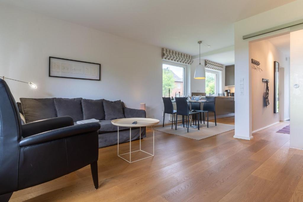 a living room with a couch and a table at Reetdachhaus Dünen Lounge in Böhl
