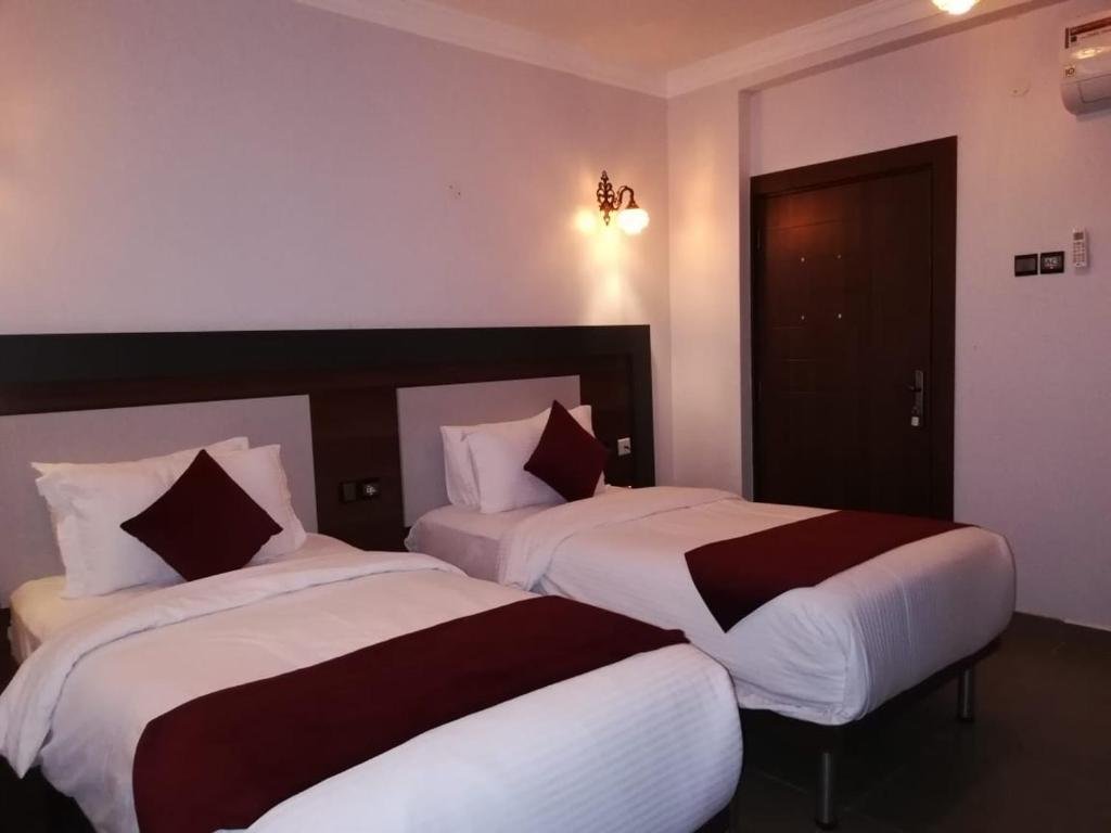 een hotelkamer met 2 bedden in een kamer bij MY HOTEL Nizwa Residence Hotel Apartement نزوى ريزيدنس in Nizwa