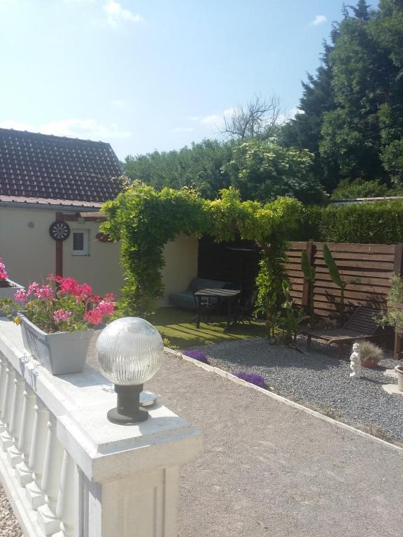 un jardín con una valla blanca y un banco en Le Paradis, en Fressies