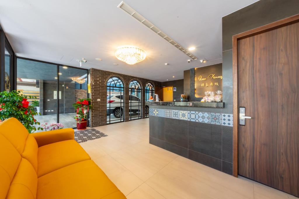 a lobby with a yellow couch and a bar at Qun Xiang Hotel in Anping