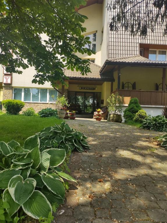 a house with a walkway in front of a building at Zajazd u Kmity in Postołów