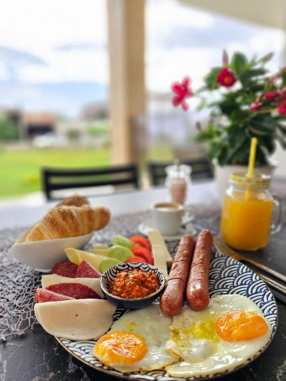 een ontbijtbord met eieren, worst en brood op tafel bij Lira Suites in Donji Štoj