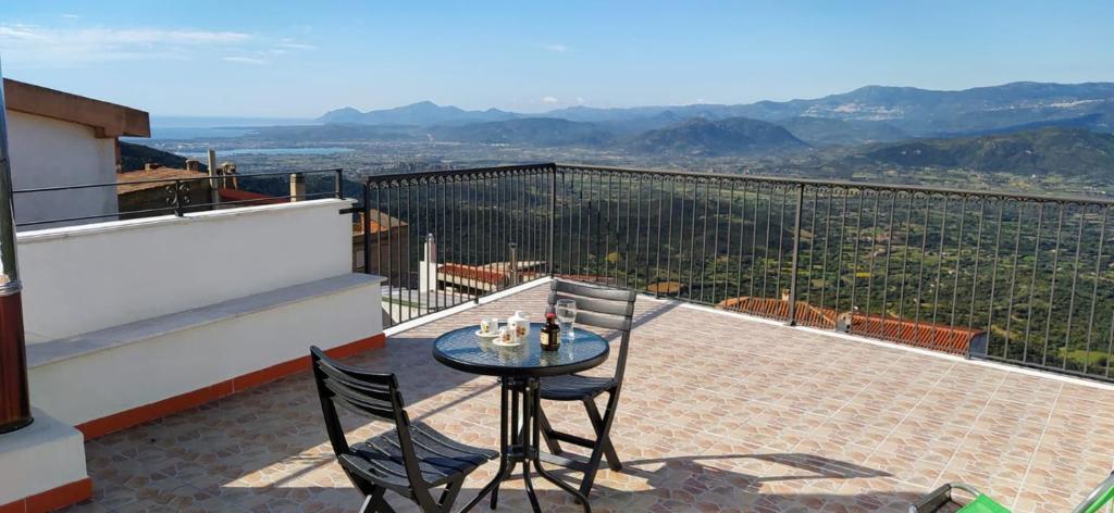 a table and chairs on a balcony with a view at House Mare & Supramonte in Baunei