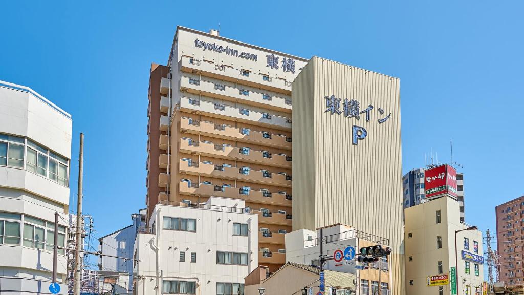 a building with a sign on it in a city at Toyoko Inn Osaka JR Noda Ekimae in Osaka