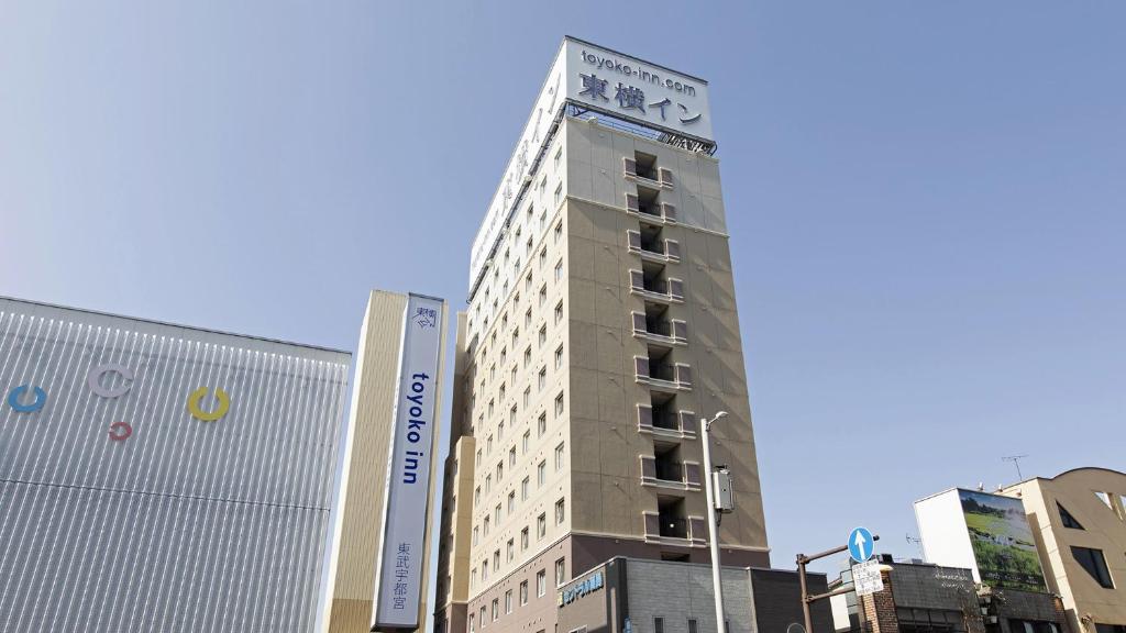 um edifício alto com uma placa na lateral em Toyoko Inn Tobu Utsunomiya eki Nishi guchi em Utsunomiya