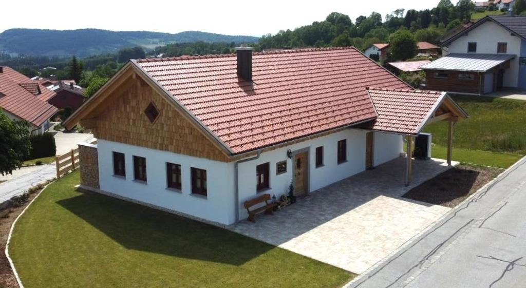 een klein wit huis met een rood dak bij Chalet Zur Wildrose in Freyung
