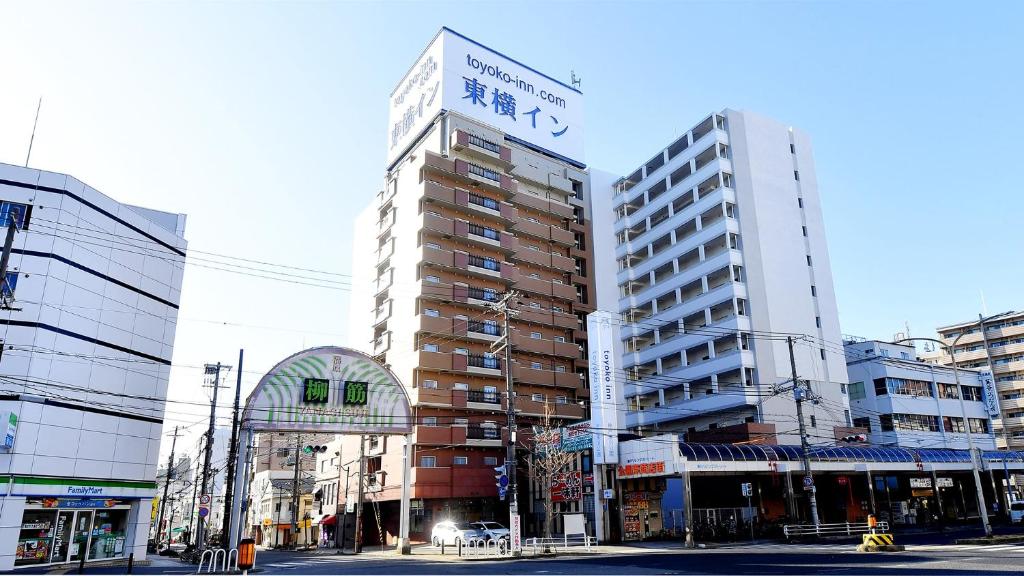 een hoog gebouw met een bord erop bij Toyoko Inn Kobe Minatogawa Koen in Kobe