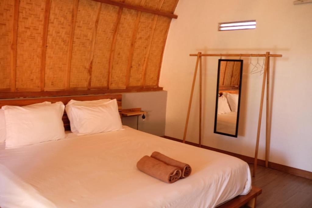 a bedroom with a bed with a towel on it at Tentacle Bali in Nusa Penida