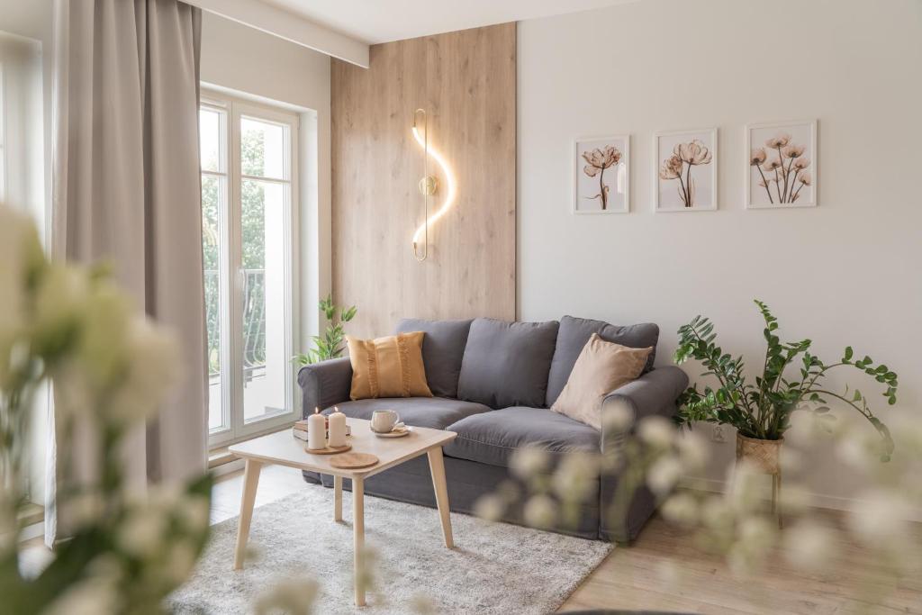 a living room with a blue couch and a table at Apartament Kameralis Old Town - klimatyzacja - balkon - winda in Elblag
