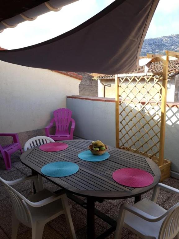 - une table sur un balcon avec des chaises et une table dans l'établissement Corbieres près mer, à Vingrau