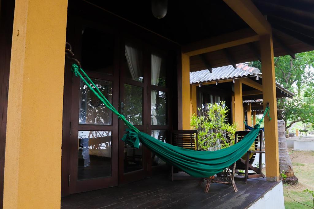 a hammock on the porch of a house at Mambo’s hotel Arugam Bay in Pottuvil