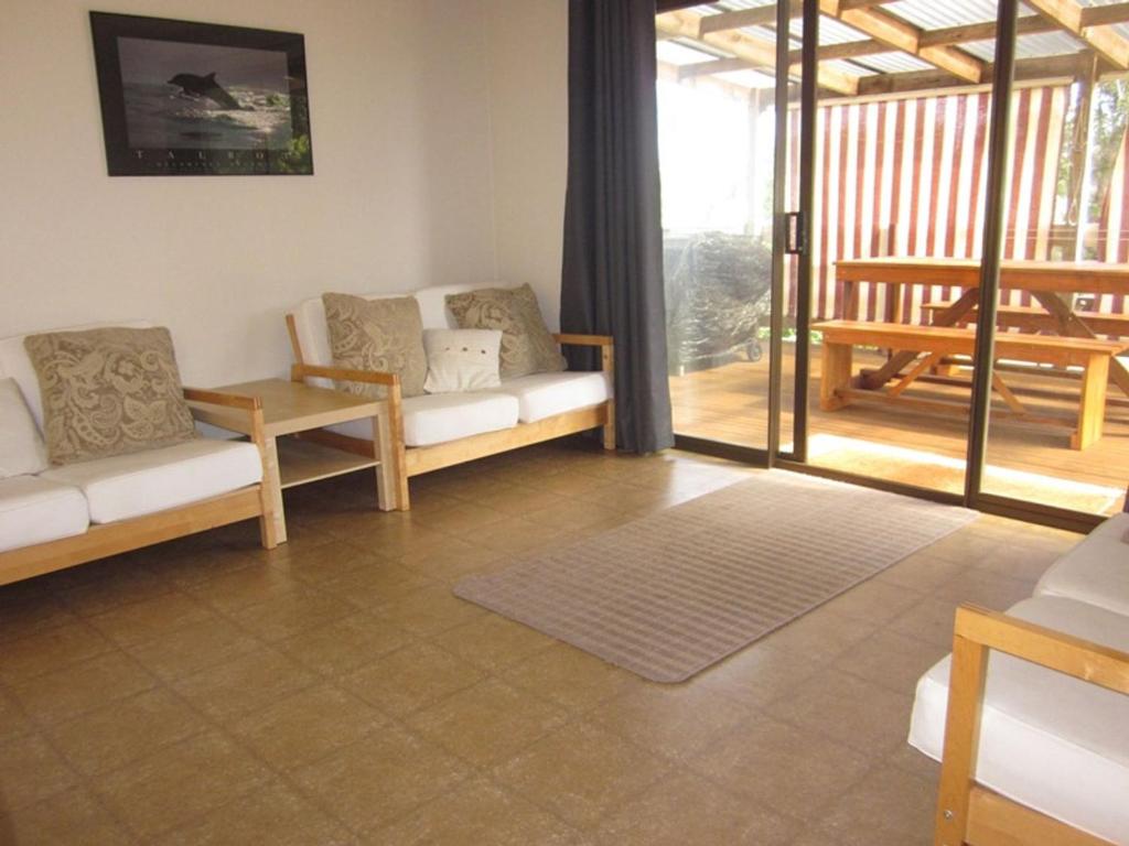 a living room with two couches and a patio at Beachcomber Bliss in Smiths Beach