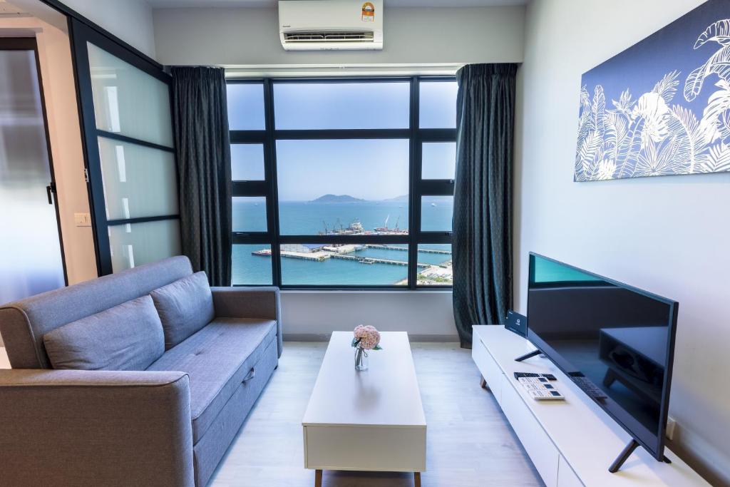 a living room with a couch and a large window at Margo Home - Jesselton Quay in Kota Kinabalu