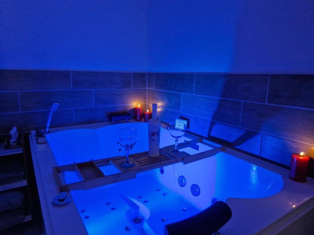 a bathroom with a tub with two candles and two wine glasses at Au Spa de LLEA in Avignon