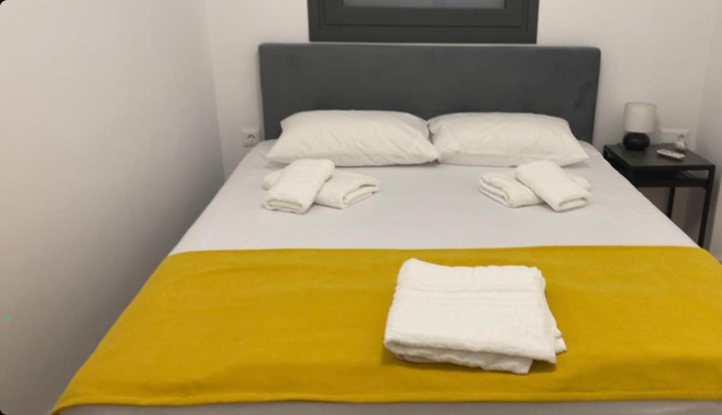 Una cama con toallas blancas encima. en HOME OF OLYMPOS, en Litóchoron