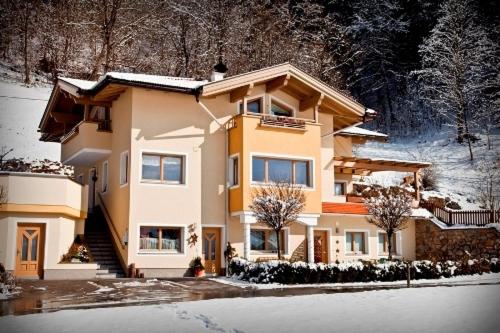 una casa grande con nieve en el suelo en Apart Angela, en Mayrhofen