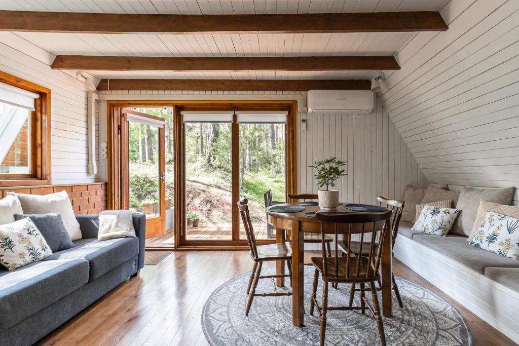 a living room with a table and a couch at Maro Guesthouse with Sauna in Vääna-Jõesuu