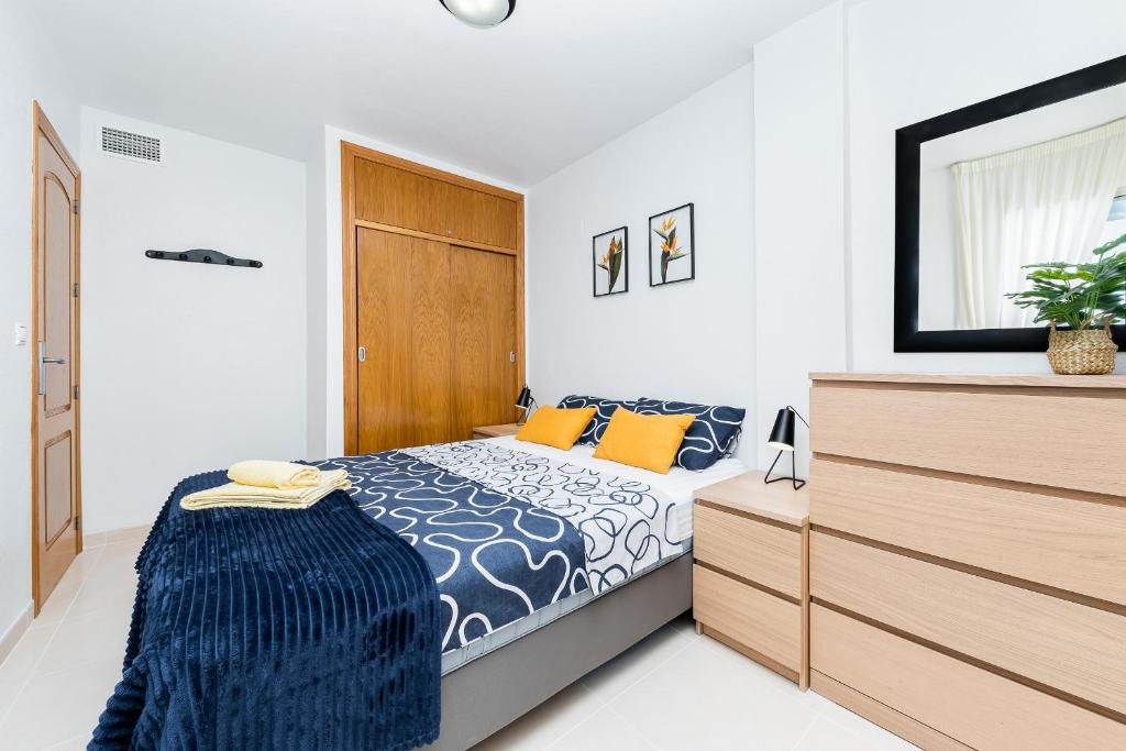 sypialnia z łóżkiem i komodą w obiekcie Apartament Playa de Los Locos w mieście Torrevieja