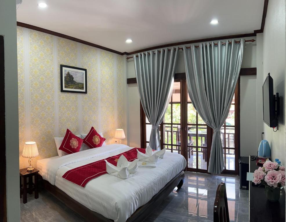 1 dormitorio con cama y ventana grande en Le KhounSok Boutique Hotel en Luang Prabang