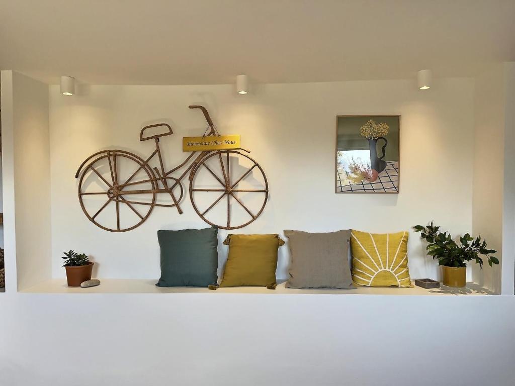 un vélo suspendu sur un mur à côté d'un canapé dans l'établissement La petite bohême K6conciergerie, à Cassis