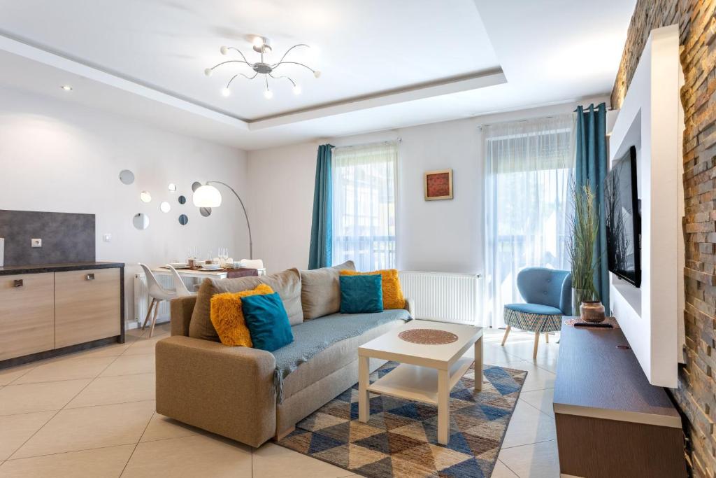 een woonkamer met een bank en een keuken bij Panorama Blue Apart Invest in Szklarska Poręba