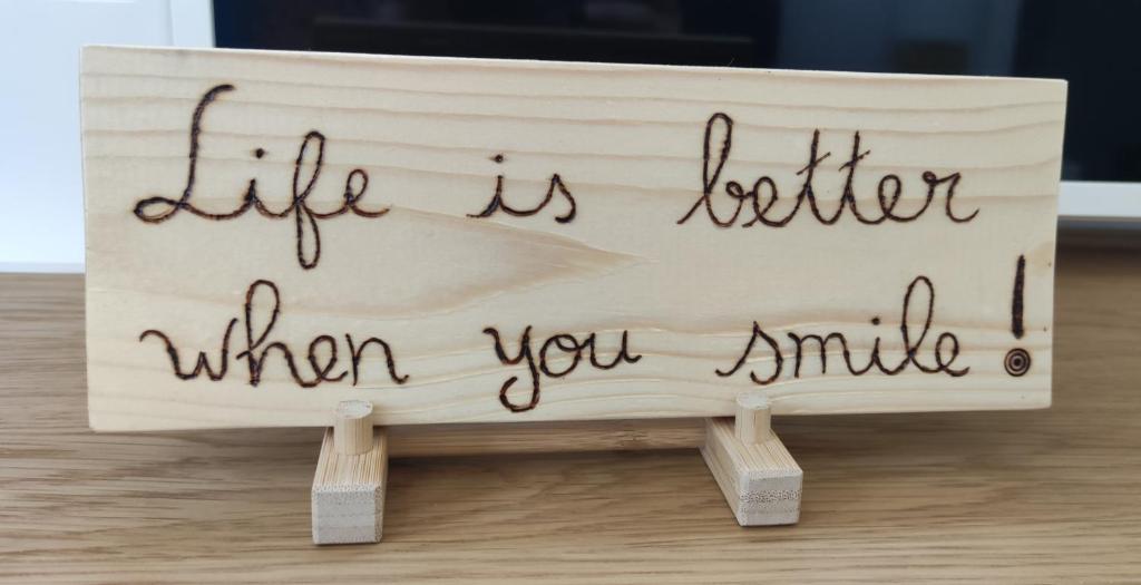 Un cartel que dice la vida es mejor cuando sonríes en O Encanto da Vila, en Vila Real de Santo António