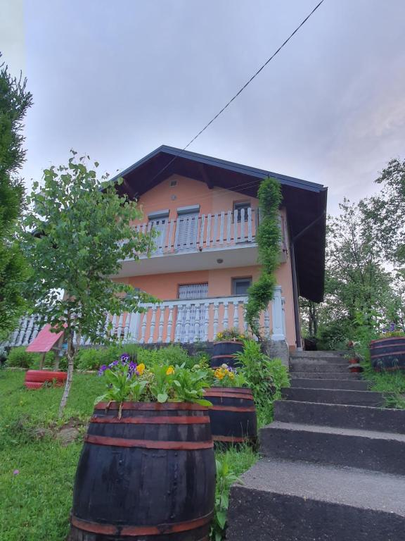 une maison avec deux grands barils devant elle dans l'établissement Vikendica Cokori, à Banja Luka